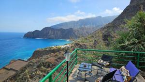 a balcony with chairs and a view of the ocean at Los Cerrajones: spectacular views from the cliff in Agulo