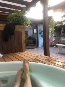 una persona acostada en una bañera con sus pies en ella en Hostel House Santinho, en Florianópolis