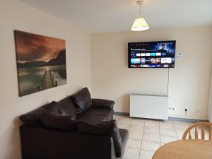 salon z kanapą i telewizorem na ścianie w obiekcie 39 Marine Court Apartment w mieście Bundoran