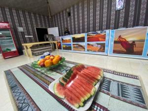 a table with a plate of fruit on a table at Miral Night Camp in Wadi Rum