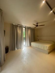 1 dormitorio con 1 cama y ventilador de techo en Casa Hood By the Sea en Holbox Island