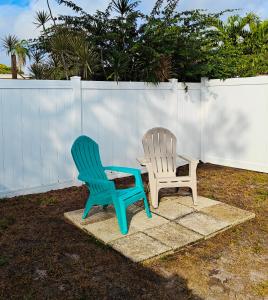 two plastic chairs sitting next to a white fence at Gorgeous suite central location in St. Petersburg
