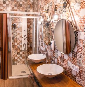 a bathroom with two sinks and a mirror at La Posada de Dulcinea in Mota del Cuervo