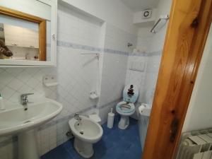 uma casa de banho branca com um lavatório e um WC em Ischia Ponte romantic apartment in the historical center and near the sea em Ischia