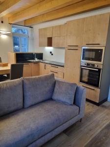 a living room with a blue couch in a kitchen at Appartamento Vale e Schena Cortina 4 posti letto in San Vito di Cadore