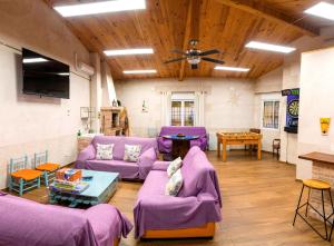 a living room with purple couches and a table at La Posada de Dulcinea in Mota del Cuervo