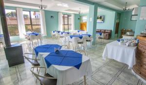 un comedor con mesas y sillas con sombrillas azules en Hotel Rocas del Pacifico en Pichilemu