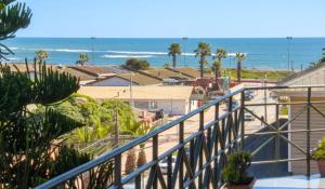 a balcony with a view of the beach and the ocean at Hotel Rocas del Pacifico in Pichilemu