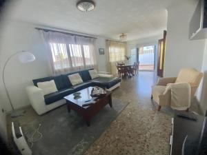 Casa la Pineda Salou, playa y Port Aventura في سالو: غرفة معيشة مع أريكة وطاولة