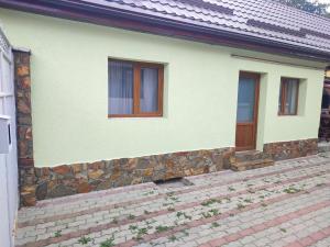 ein Haus mit einer Steinmauer und einer Holztür in der Unterkunft Torok Adrian Mihail PFA in Râșnov