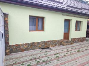 a house with a stone wall and a wooden door at Torok Adrian Mihail PFA in Râşnov