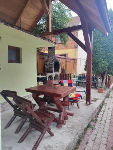 einen Picknicktisch aus Holz und Stühle auf einer Terrasse in der Unterkunft Torok Adrian Mihail PFA in Râșnov