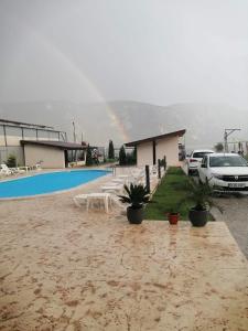 een regenboog over een huis met een auto ernaast bij Vila Hercules in Dubova