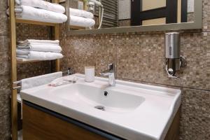 a bathroom with a sink and a mirror and towels at Apartament Premium Borealis in Timişoara +25 photos