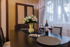 a dining room table with a vase of flowers and wine glasses at Apartament Premium Borealis in Timişoara