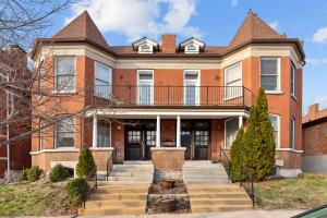 a brick house with a balcony on top of it at Exquisitely Designed Townhome - JZ Vacation Rentals in Saint Louis