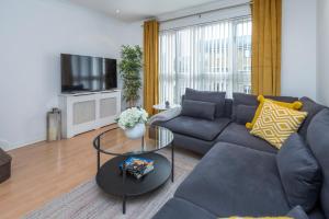 a living room with a couch and a tv at 2 Bed town house with Garden in Hackney, London in London