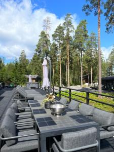 une terrasse avec une table, des chaises et des arbres dans l'établissement Grand Hideout Lake Päijänne, à Vääksy