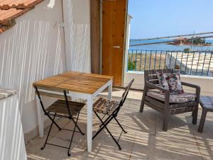 una mesa y sillas en un balcón con vistas al océano en Stanza panoramica con terrazza privata sul mare, en Marzamemi