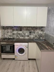 een keuken met een wasmachine en een wastafel bij Sofi Studio Central in Boekarest