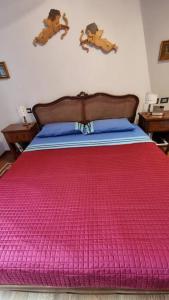 a large bed with a pink blanket on it at Stanza dei Mercanti in Orvieto