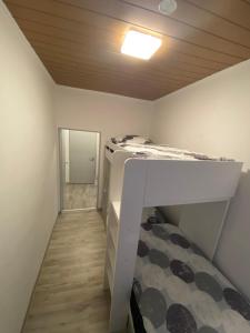 a small room with a bunk bed and a ceiling at Gemütliches Apartment mit Kamin in Oldenburg