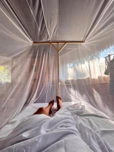 a person laying on a bed under a canopy at Eywa Lodge Amazonas - All inclusive in Yucuruche