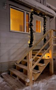 un escalier menant à une maison aux lumières de Noël dans l'établissement Aron Hill Home, à Rovaniemi