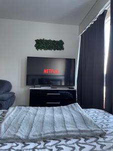 sypialnia z telewizorem z płaskim ekranem i łóżkiem w obiekcie Suncatcher Studio w mieście Berno