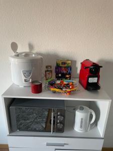 uma prateleira branca com uma máquina de café em cima em Suncatcher Studio em Berna