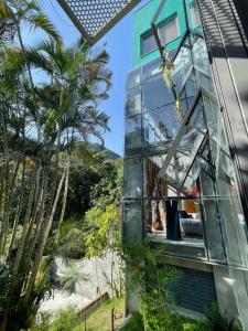 a person climbing up the side of a glass house at Emerald House in Rio de Janeiro
