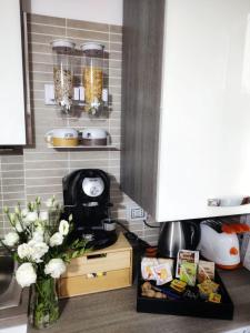 - un comptoir de cuisine avec une cafetière et un vase de fleurs dans l'établissement Premier Apartment Milano, à Milan