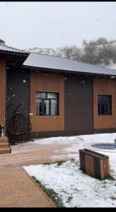 a building with snow in front of it at Amirsoy Apple Dacha in Chimgan