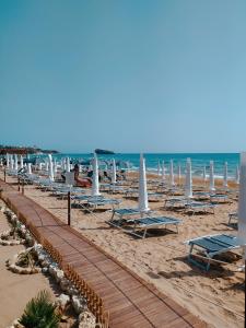 a beach with chairs and umbrellas and the ocean at Appartamento Porto Marina in Licata