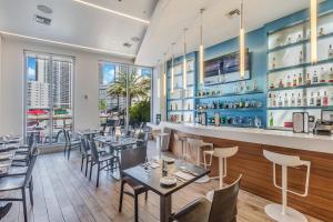 a restaurant with tables and chairs and a bar at Water View Building With Pool - 5-Min Walk To The Beach - Cozy Studios in Hallandale Beach