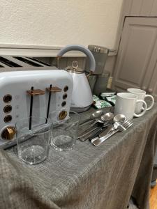 a table with a toaster and glasses on it at Luxury apartment studio in central cardiff in Cardiff