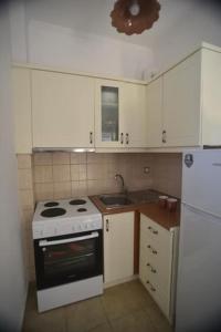 La cuisine est équipée d'une cuisinière, d'un évier et d'un réfrigérateur. dans l'établissement Anna's Central Hideaway, à Ágios Rókkos