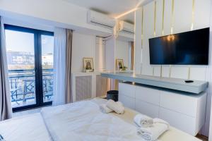 a bedroom with a large bed with a flat screen tv at Hi-lux Ultracentral - 4BR Superior - Amazing View in Bucharest