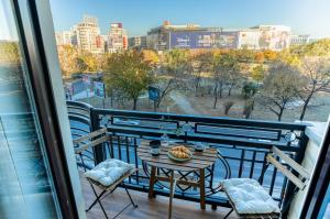 a table and chairs on a balcony with a view at Hi-lux Ultracentral - 4BR Superior - Amazing View in Bucharest