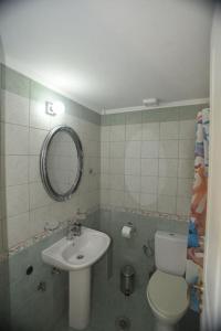 La salle de bains est pourvue d'un lavabo, de toilettes et d'un miroir. dans l'établissement Anna's Central Hideaway, à Ágios Rókkos