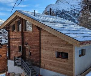a log cabin with a snow covered roof at Chalet Adler in Saas-Fee