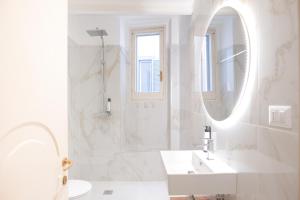 a white bathroom with a sink and a mirror at Loft 5c - Palatino in Rome +170 photos