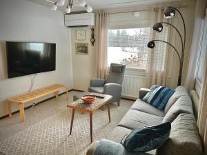 a living room with a couch and a table at Chalet Mummola in Naamijoki