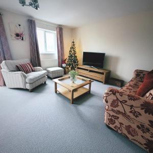 a living room with a christmas tree and a couch at Golden Valley View in Codnor