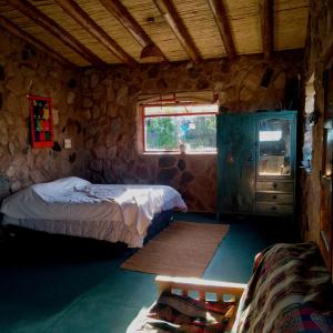 1 dormitorio con 2 camas, vestidor y ventana en Refugio de Montaña "Casa Chakana " en Luján de Cuyo
