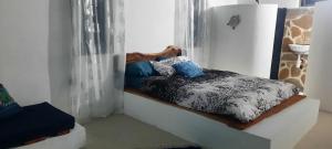 een klein bed in een kamer met een giraffe bij Le lataniers in Rodrigues Island