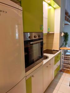 a kitchen with green and white cabinets and a refrigerator at Apartman Stepa K3 in Belgrade
