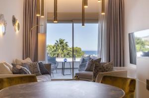 a living room with a table and a view of the ocean at Dionis Boutique Hotel & Spa in Jávea