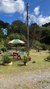 a picnic table and an umbrella in a yard at Cabanas Brocker in Gramado