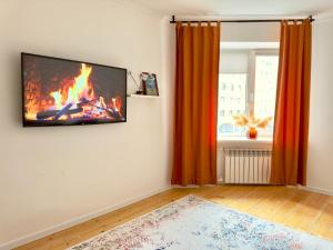 a living room with a fire on the wall at Двушка около Академии Scandinavian Style in Atyrau
